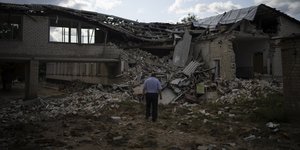 Ανδρας στέκεται σε συντρίμμια σπιτιού