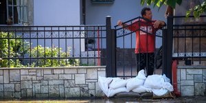 Ανδρας σε εισοδο σπιτιού μπροστά σε πλημμυρισμένο δρόμο