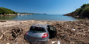 Αυτοκίνητο θαμμένο μέσα στην άμμο σε παραλία, μετά το πέρασμα της κακοκαιρίας Daniel