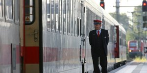 Σταθμάρχης περπατά δίπλα από τρένο