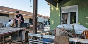 Νεαρός στο κατεστραμμένο σπίτι του