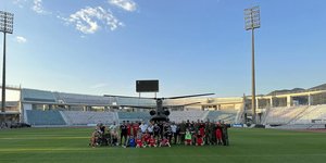 Οι ποδοσφαιριστές του Βόλου στο Πανθεσσαλικό, με φόντο το σινούκ που φόρτωσαν με είδη πρώτης ανάγκης για το Πήλιο / Φωτογραφία: Volosday.gr