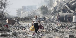 Άνθρωπος περπατά στα συντρίμμια στη Γάζα