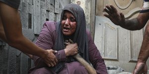 Μια τραυματισμένη Παλαιστίνια κλαίει καθώς κρατάει το χέρι του νεκρού συγγενή της έξω από το σπίτι της μετά τις ισραηλινές αεροπορικές επιδρομές που είχαν στόχο τη γειτονιά τους στην πόλη της Γάζας