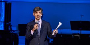 Τζόρτζ Στεφανόπουλος με μικροφωνο κ χαρτι 