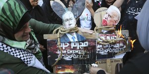 Παλαιστίνιοι διαδηλωτές καίνε φωτογραφίες που απεικονίζουν τον πρόεδρο των ΗΠΑ Τζο Μπάιντεν, δεξιά, και τον Ισραηλινό πρωθυπουργό Μπέντζαμιν Νετανιάχου, αριστερά