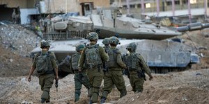 Ισραηλινοί στρατιώτες περπατούν στη Γάζα, μπρστά από ένα τεθωρακισμένο όχημα