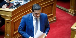 Ο Μιχάλης Κατρίνης περπατά μέσα στη Βουλή κρατώντας έγγραφα