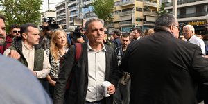 Ο Ευκλείδης Τσακαλώτος περπατάει με καφέ