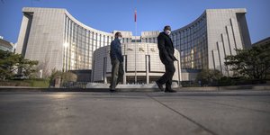 Ανδρες περπατούν έξω από ομοσπονδιακό κτίριο της Κίνας