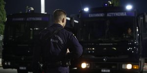 Αστυνομικός μπροστά από κλούβες