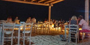 Κόσμος απολαμβάνει το φαγητό σε ελληνικό εστιατόριο