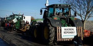 «Μακρόν, απάντησε!» γράφει ένα πανό σε τρακτέρ αγροτών της Γαλλίας που διαμαρτύρονται