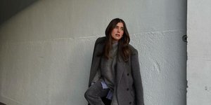 γυναίκα με γκρίζο παλτό και τζιν