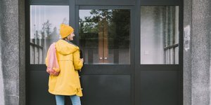 γυναίκα με κίτρινο παλτό σε σπίτι