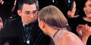 H Τέιλορ Σουίφτ συνομιλεί με τον συνεργάτη της, κρυμμένη πίσω από μια βεντάλια