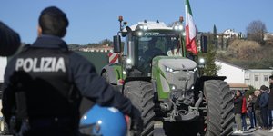 Αστυνομικός μπροστά από τρακτέρ με σημαία Ιταλίας