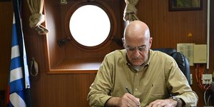 O Νίκος Δένδιας υπογράφει σε βιβλίο στην φρεγάτα Υδρα