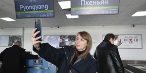 Ρωσίδα τουρίστρια βγάζει μια selfie μετά το check-in για να επιβιβαστεί σε αεροπλάνο για να πετάξει στη Βόρεια Κορέα