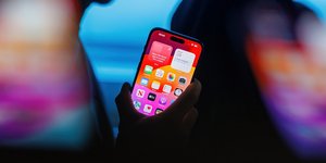 Άνδρας που κρατά ένα iPhone 15 Pro