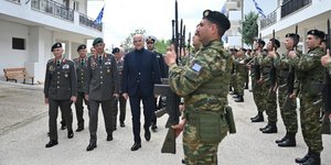 Στρατιώτες στέκονται προσοχή μπροστά στον Δένδια