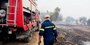 Πυροσβέστης δίπλα σε πυροσβεστικό όχημα