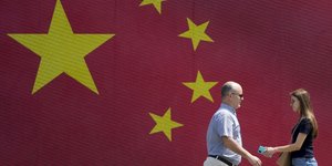 Άνθρωποι περπατούν μπροστά από ένα τοίχο στα χρώματα της Κίνας στο Βελιγράδι της Σερβίας