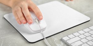 Χέρι σε ποντίκι υπολογιστή που ακουμπά σε mousepad
