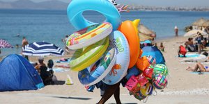 Άνδρας πουλά φουσκωτά σε παραλία