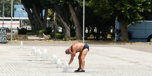 Ένα άνδρας προσπαθεί να δροσιστεί σε συντριβάνι