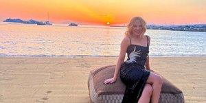 Η Κάιλι Μινόγκ με μαύρο φόρεμα στο ηλιοβασίλεμα