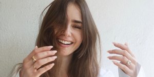 Η Λίλι Κόλινς με μακριά μαλλιά και λευκό πουκάμισο