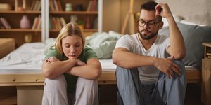 ζευγάρι κάθεται μπροστά από το κρεβάτι