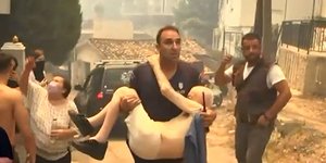 Αστυνομικός κρατάει αγκαλιά ηλικιωμένο να τον σώσει από φωτιά