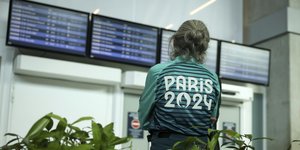 Εθελόντρια των Ολυμπιακών Αγώνων κοιτάζει οθόνες στο αεροδρόμιο