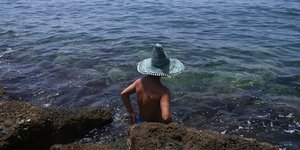 Άνδρας με καπέλο στην παραλία