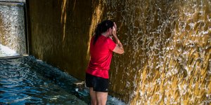 Γυναίκα δροσίζεται σε σιντριβάνι εν μέσω καύσωνα 