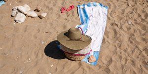 Παραλία με πετσέτα θαλάσσης και καπέλο