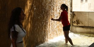 Γυναίκα δροσίζεται σε σιντριβάνι εν μέσω καύσωνα