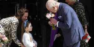 O βασιλιάς Κάρολος μυρίζει λουλούδια που του προσφέρουν