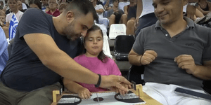 Συνοδός βοηθά κοριτσάκι με προβληματα όρασης να παρακολουθήσει τον αγώνα μπάσκετ της εθνικής