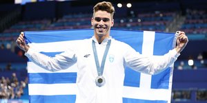 O Aπόστολος Χρήστου με το μετάλλιο και την ελληνική σημαία