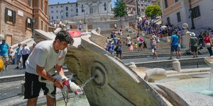 Ιταλός δροσίζει το σκυλί του από τον καύσωνα στην Πιάτσα ντ' Εσπάνια της Ρώμης 