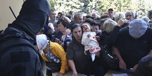 Άνθρωποι στην περιοχή του Κουρσκ σχηματίζουν ουρά για να συμπληρώσουν το έντυπο για ανθρωπιστική βοήθεια σε κέντρο διανομής ανθρωπιστικής βοήθειας