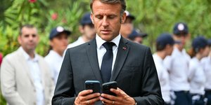 Ο Μακρόν κοιτάζει δύο κινητά