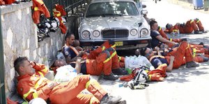 Αποκαμωμένοι πυροσβέστες ξεκουράζονται