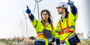 Ανδρας και γυναίκα εργαζόμενοι σε ανεμογενήτριες