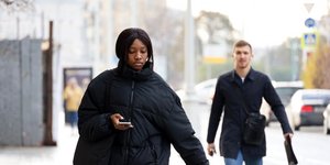 Αφρικανή κοιτάζει το κινητό της περπατώντας στη Μόσχα