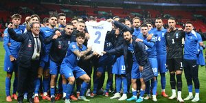 Οι παίκτες της Εθνικής, κρατώντας τη φανέλα του αδικοχαμένου Τζορτζ Μπάλντοκ πανηγυρίζουν τη νίκη επί της Αγγλίας στο Γουέμπλεϊ 
