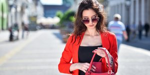 Γυναίκα κρατά μια κόκκινη τσάντα